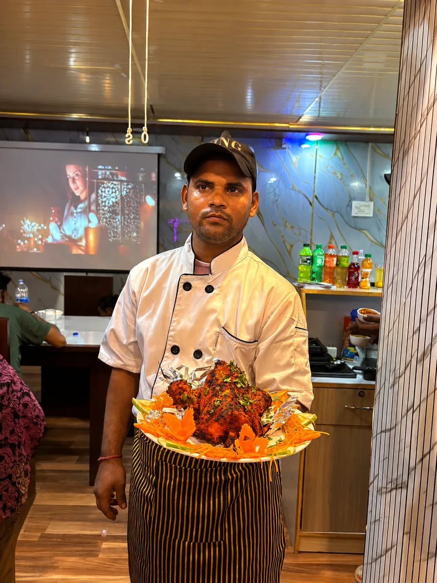 Chef carrying a tandoori platter